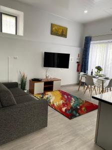 a living room with a couch and a flat screen tv at Casa Bela Vista in Ponta Delgada