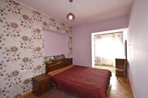 a bedroom with a red bed and a window at Ararat view 3-bedroom apartment with garden in Yerevan