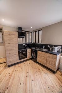 a large kitchen with wooden floors and a counter top at Appartement - Le Mikado - Hyper-centre - Wi-Fi- Espace de travail - Confort in Saint-Étienne