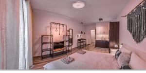 1 dormitorio con paredes rosas, 1 cama y cocina en Waterfront Boutique Suite, en Budapest