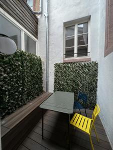 een tafel en een gele stoel op een patio bij Centre ville Haguenau - 5pers in Haguenau