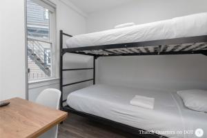 a bedroom with two bunk beds and a desk at Quarters on DOT by Thatch in Boston