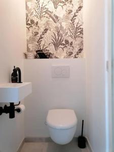 La salle de bains est pourvue de toilettes blanches et d'un lavabo. dans l'établissement CoZB, à Bruges