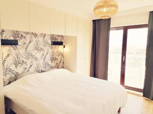 een slaapkamer met een wit bed en een raam bij CoZB in Brugge