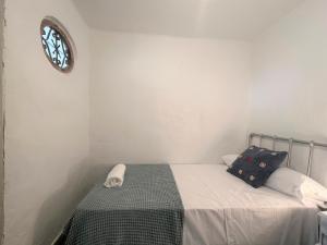um quarto com uma cama e um relógio na parede em BnS - Casa La Prensa - Alpujarra em Sorvilán