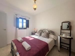 Schlafzimmer mit einem Bett, einem Spiegel und einem Fenster in der Unterkunft BnS - Casa La Prensa - Alpujarra in Sorvilán