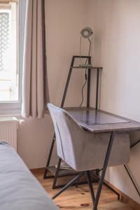 a desk in a bedroom with a chair and a lamp at Appartement - Le Mikado - Hyper-centre - Wi-Fi- Espace de travail - Confort in Saint-Étienne