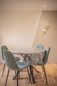 a dining room table with four green chairs at Appartement - Le Mikado - Hyper-centre - Wi-Fi- Espace de travail - Confort in Saint-Étienne