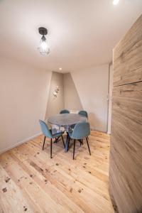 a dining room with a table and blue chairs at Appartement - Le Mikado - Hyper-centre - Wi-Fi- Espace de travail - Confort in Saint-Étienne
