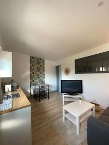 uma sala de estar com um sofá e uma mesa em Maisonnette cosy à 10 mn de Nantes em Rezé