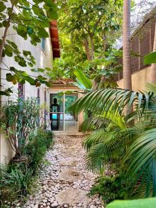 einen Weg zu einem Haus mit Bäumen und Pflanzen in der Unterkunft Heated Pool! 1 Minute Walk To The Beach! PURA VIDA Villa in Herzlia