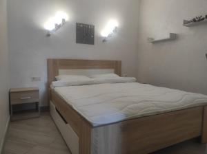 uma cama num quarto com duas luzes na parede em Апартаменти в новобудові em Kulʼparkuv