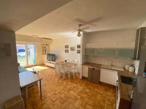 a kitchen and living room with a table and chairs at Lucy Apartment Piran-Punta in Piran