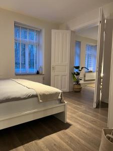 sypialnia z łóżkiem oraz korytarz z oknami w obiekcie Ferienwohnung in Bad Bramstedt w mieście Bad Bramstedt