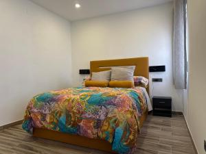 - une chambre avec un lit et une couette colorée dans l'établissement Alamos Suite, à Jaén