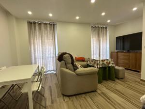 - un salon avec un canapé, une télévision et une table dans l'établissement Alamos Suite, à Jaén