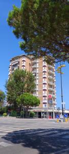 a large building with a tree in front of it at Residence Adriatico in Lido Adriano
