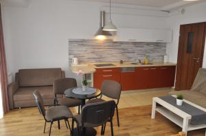 a kitchen and a living room with a table and chairs at Apartament Bażantowo in Katowice