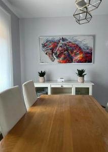una sala da pranzo con tavolo e un dipinto sul muro di Casa La Rosada a Garray