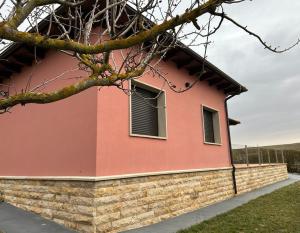 uma casa cor-de-rosa com uma parede de tijolos em Casa La Rosada em Garray