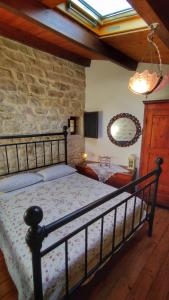 a bedroom with a bed and a stone wall at Lilibeth Houses - Charming & Lovely views in Scicli