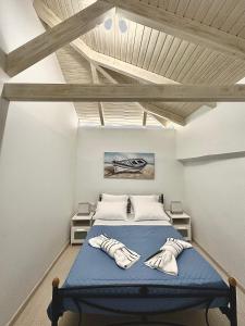 a bedroom with a blue bed and wooden ceilings at WoodHome in Kalamitsi