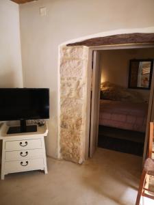 una camera con letto e scrivania con TV di Casa Opuntia a Pappayiannádhes