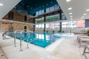 a large swimming pool in a large building at Apartament Biały w Rewalu in Rewal