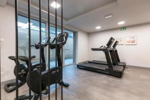 a gym with treadmills and ellipticals in a room at Apartament Biały w Rewalu in Rewal
