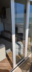 a sliding glass door with a view of the ocean at Residence Adriatico in Lido Adriano