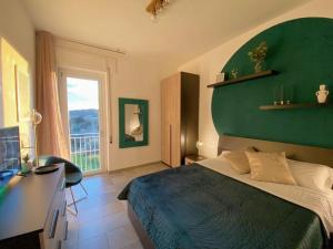 um quarto com uma cama, uma secretária e uma parede verde em Villa Boeddu, relax tra mare e campagna em Alghero