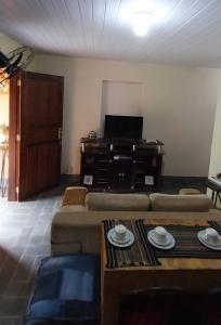 sala de estar con sofá y mesa en Sitio148 Hospedaria en Penedo