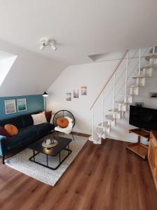 a living room with a couch and a staircase at Apartment Luise in Friedrichskoog