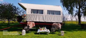 a white trailer with a table in the grass at De Huifkar, bij Sneek aan elfstedenroute in Hommerts