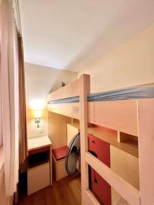 Cette petite chambre comprend des lits superposés et un bureau. dans l'établissement CAP ESTEREL AGAY SAINT RAPHAEL VUE MER Studio 4 personnes chez Evelyne, à Saint-Raphaël