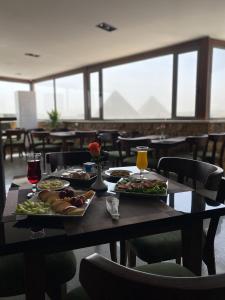 a table with plates of food and drinks on it at The View Delta Hotel in Cairo