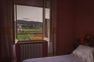 a bedroom with a window with a view of a field at Casa di nonna in Bevagna