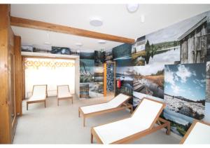 a waiting room with chairs and posters on the wall at Apartman 22, Rezidence & Wellness Javor in Železná Ruda