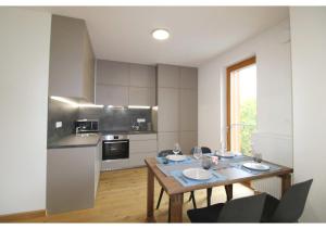 een keuken met een houten tafel met stoelen erin bij Apartman 22, Rezidence & Wellness Javor in Železná Ruda