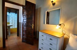 a bedroom with a dresser with a mirror and a lamp at La Casina de la Huerta in Llanes