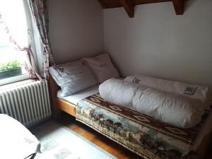 Una cama pequeña en una habitación con ventana. en Alpin Ranch, en Zărneşti 17 fotos más