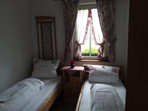 Dos camas individuales en una habitación con ventana. en Alpin Ranch, en Zărneşti