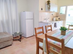a kitchen with a dining table and a white refrigerator at Spot in the Village פינה במושב in Livnim