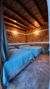 una camera con due letti in un edificio con soffitti in legno di Hotel Colibrí Petén a Santa Elena