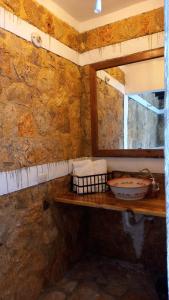 uma casa de banho com um balcão com um lavatório e uma janela em Hotel Colibrí Petén em Santa Elena