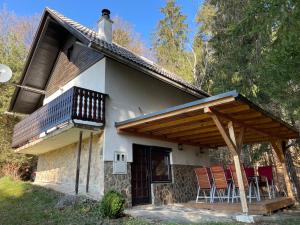 une maison avec une terrasse et des chaises sur le toit dans l'établissement Vintage Holiday House, à Šoštanj