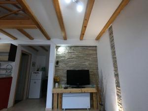 a living room with a television and a brick wall at Villa Lyra in Trebinje