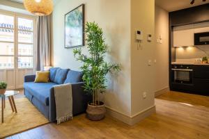 salon z niebieską kanapą i rośliną w obiekcie Elegante 3 dormitorios en Centro Historico Málaga w Maladze
