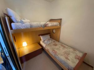 ein kleines Zimmer mit 2 Etagenbetten und einer Lampe in der Unterkunft Villa Dune in Campomarino