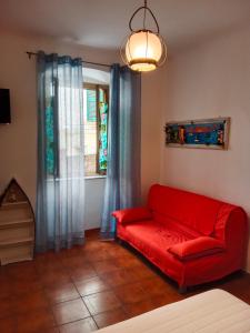 a red couch in a living room with a window at MOLO 37 in La Spezia
